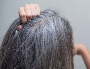 woman grabbing her grey hair